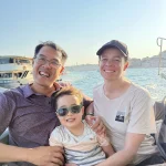 Family on a private Bosphorus boat tour in the daytime passing Ortaköy Mosque in Istanbul