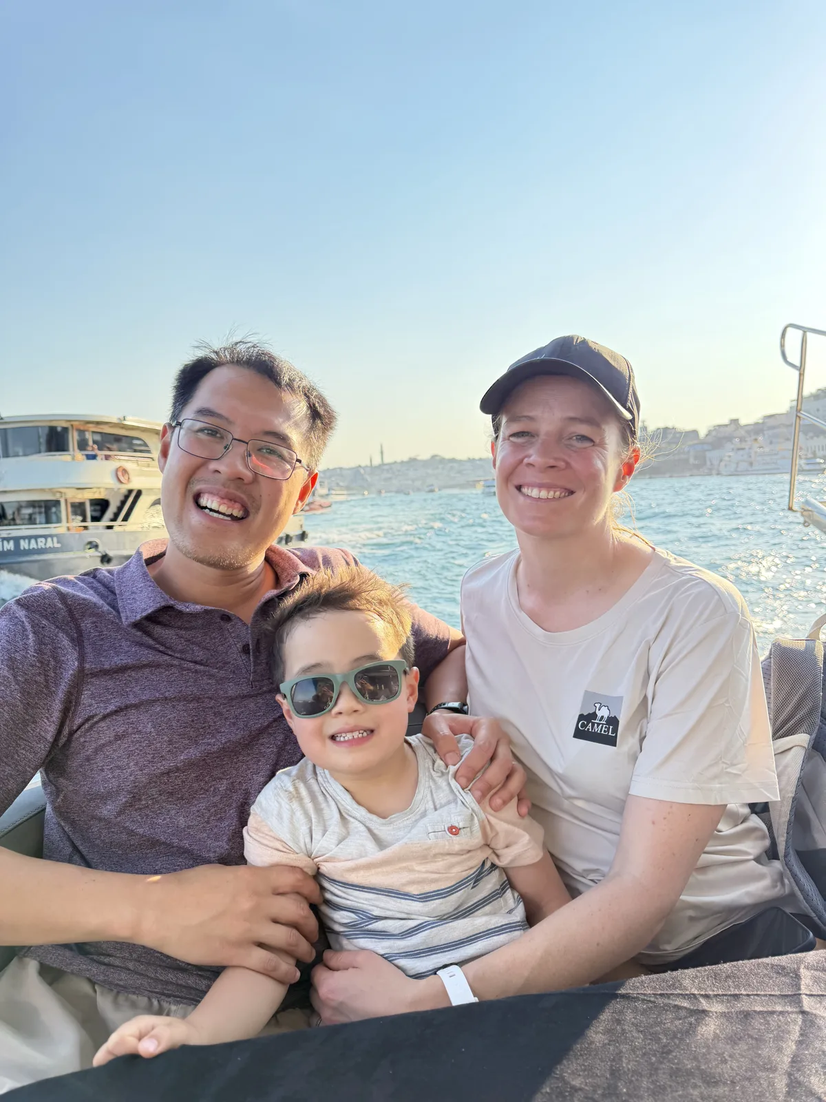 Family on a private Bosphorus boat tour in the daytime passing Ortaköy Mosque in Istanbul